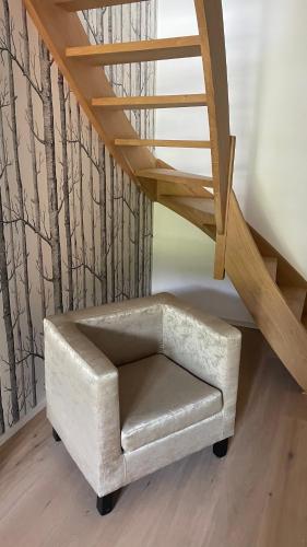 a chair sitting under a stairs with a stair case at The Refuge of Happiness in Bouillon