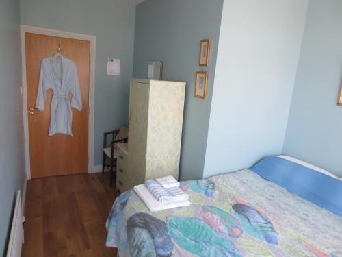 a bedroom with a bed and a robe hanging on a door at The Stone House B&B in Baltimore