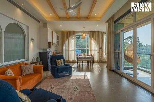a living room with a couch and chairs and a table at StayVista at The Ever House with Bonfire, Jacuzzi, Bathtub in Dharampur