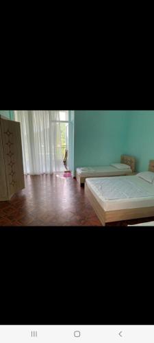 a bedroom with two beds in a room with a window at Квари in Kvariat'i