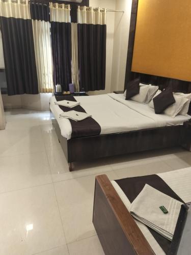 a bedroom with two beds and a table in it at Hotel Sachidanand-Walkable distance from Temple in Shirdi