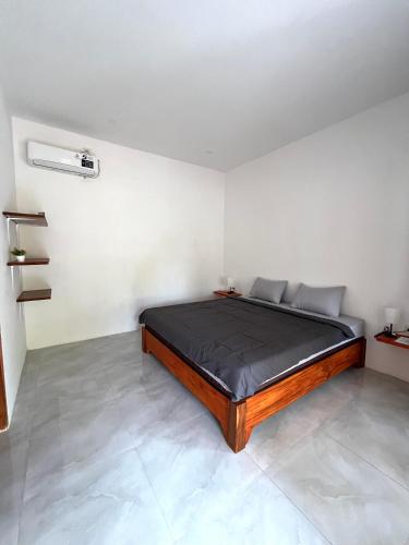a bedroom with a bed in a white room at Isirela in Kuta Lombok