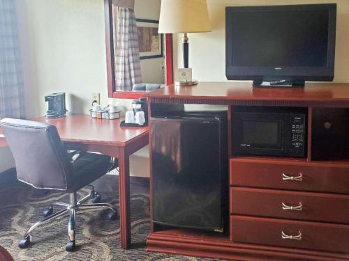 a room with a desk with a microwave and a television at Quality Inn Prattville I-65 in Prattville