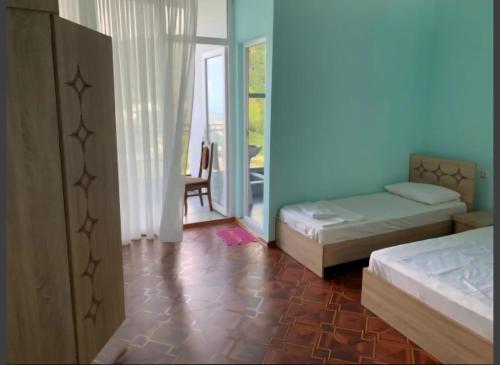 a blue room with two beds and a chair at Квари in Kvariat'i