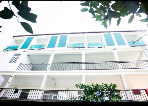 a white building with blue windows and a balcony at Квари in Kvariat'i