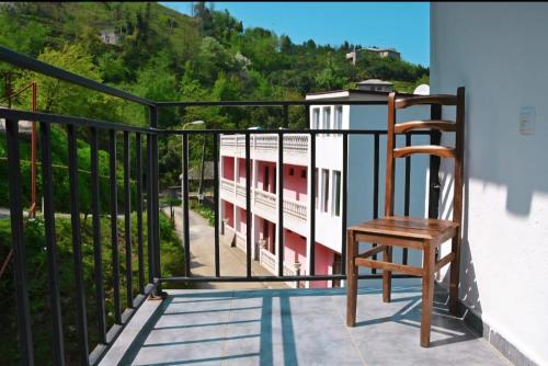 a wooden chair sitting on the balcony of a house at Квари in Kvariat'i