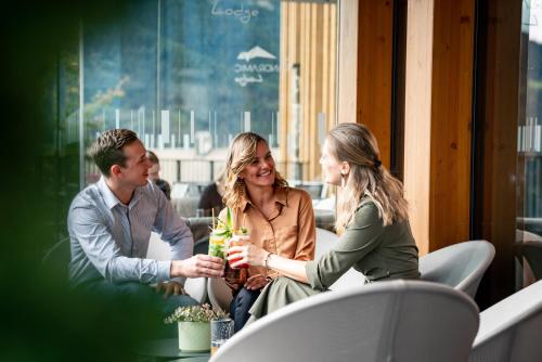 a group of people sitting around a table with drinks at Hotel Panoramic Lotsch in Sarntal
