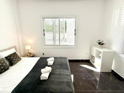 a bedroom with a large bed with two towels on it at Elegant Beach Villa Moonstone II in Meneou