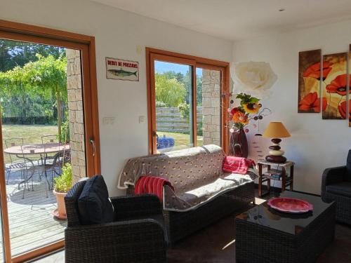 ein Wohnzimmer mit einem Sofa und einer Terrasse in der Unterkunft Maison charmante avec jardin et barbecue à Penmarch in Penmarcʼh