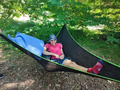a woman laying in a hammock in the grass at The Hideaway in Želiv