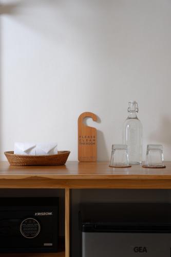 a wooden counter top with a bottle and two glasses at Green Hill Boutique Hotel in Labuan Bajo