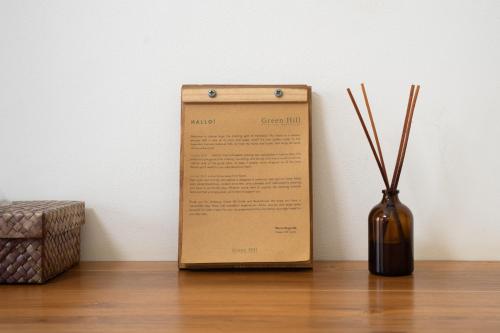 a box sitting next to a vase on a wooden floor at Green Hill Boutique Hotel in Labuan Bajo