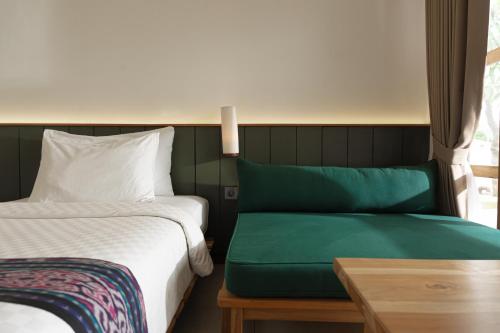a bedroom with a bed and a table and a window at Green Hill Boutique Hotel in Labuan Bajo