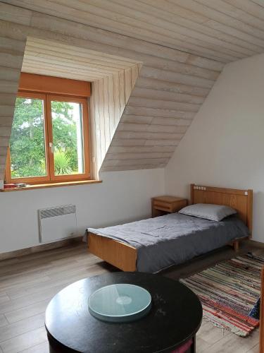 - une chambre avec un lit et une table basse dans l'établissement Maison charmante avec jardin et barbecue à Penmarch, à Penmarcʼh