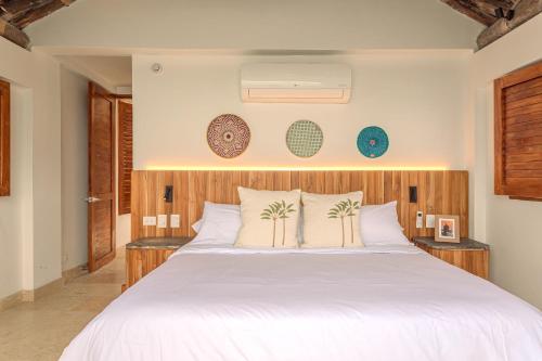 a bedroom with a large white bed with two tables at Islawa Soy Local - Isla Privada in Baru