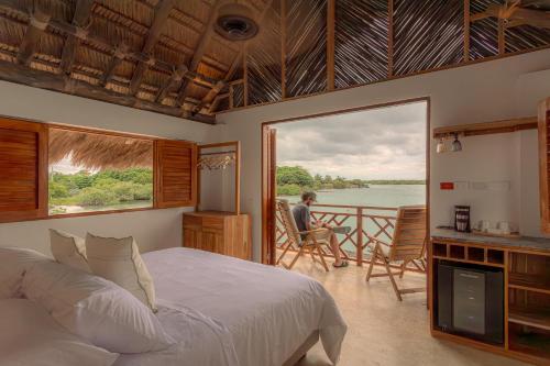 una camera da letto con un letto e vista sull'acqua di Islawa Soy Local - Isla Privada a Barú