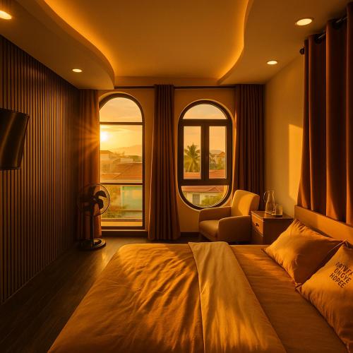 a bedroom with a large bed and two windows at Khách Sạn MINTNACIE in Phan Rang