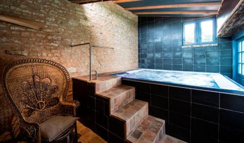 a bath room with a tub and a chair and a chair at Château de l'Abbaye - Teritoria in Moreilles