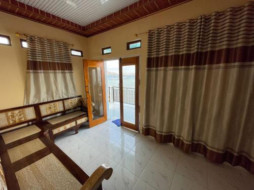 a living room with a bench and a balcony at Komodo Homestay in Komodo
