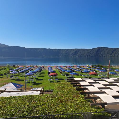 a bunch of umbrellas are lined up next to the water at La Casa di Ale - Castelli Romani in Marino