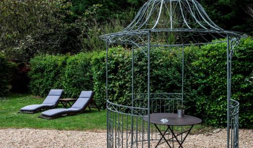 a metal bird cage with two chairs and a table at Château de l'Abbaye - Teritoria in Moreilles