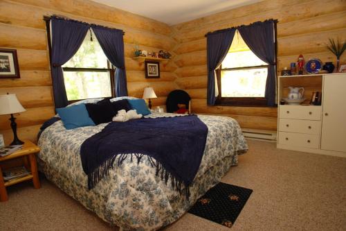 1 dormitorio con 1 cama y 2 ventanas en The Garrison Inn a Montana Bed & Breakfast, en Kalispell