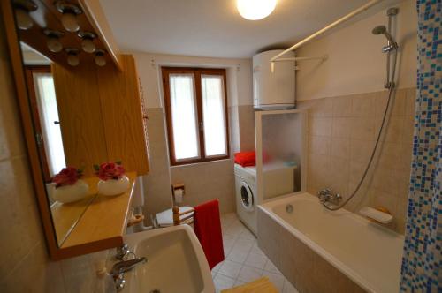 uma casa de banho com uma banheira, um lavatório e um chuveiro em Sabrina Fantasia em Campodolcino