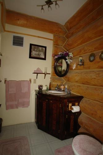 a bathroom with a sink and a wooden wall at The Garrison Inn a Montana Bed & Breakfast in Kalispell