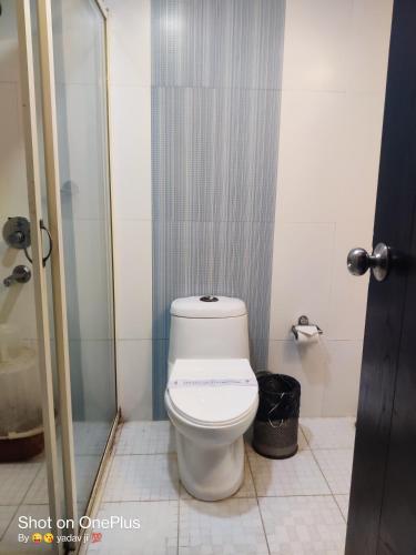 a bathroom with a white toilet in a stall at Hotel Delphi Grand Hyderabad - Hi-Tech City, Perfect for Business & Comfort in Hyderabad