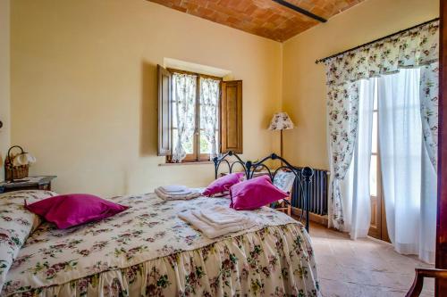 a bedroom with a bed with pink pillows on it at Agriturismo Poggio Istiano in Bagno Vignoni