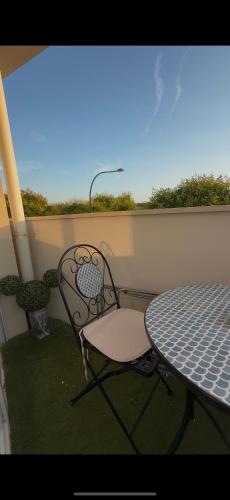 a table and a chair sitting on a balcony at La Belle et le Nooki in Meaux