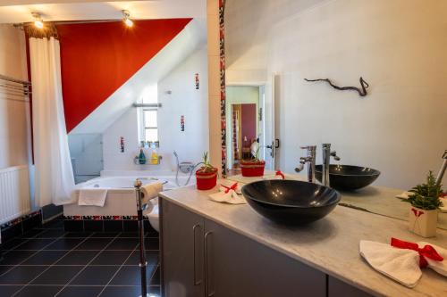 y baño con 2 lavabos y bañera grande. en Virginia's Art House, en Porto Rafti