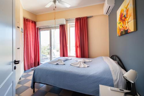 Un dormitorio con una cama y una ventana con cortinas rojas. en Virginia's Art House, en Porto Rafti