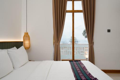 a bedroom with a bed and a large window at Green Hill Boutique Hotel in Labuan Bajo