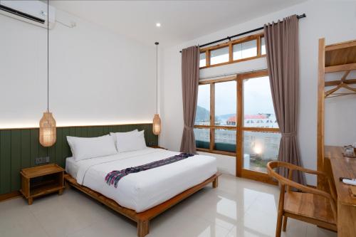 a bedroom with a bed and a large window at Green Hill Boutique Hotel in Labuan Bajo