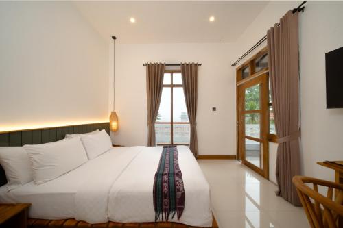a bedroom with a large bed and a window at Green Hill Boutique Hotel in Labuan Bajo