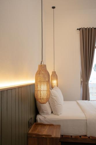 a bedroom with a bed with two lamps and a table at Green Hill Boutique Hotel in Labuan Bajo