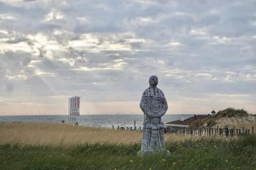 a statue of a man standing on the beach at Bed & Beach 114 in Noordwijk aan Zee