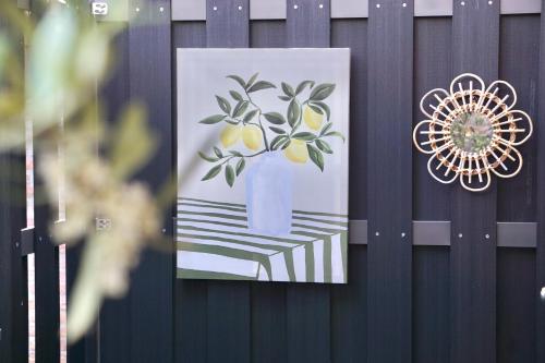 a picture of a lemon tree in a blue vase on a fence at Bed & Beach 114 in Noordwijk aan Zee