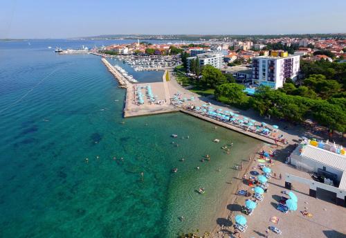 an aerial view of a beach with people in the water at Ilirija Resort Hotel Kornati in Biograd na Moru