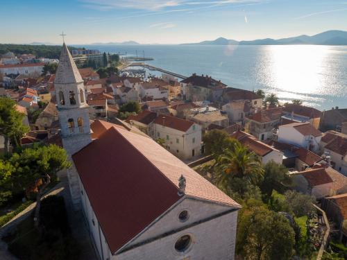an aerial view of a town with a church and the water at Ilirija Resort Hotel Kornati in Biograd na Moru