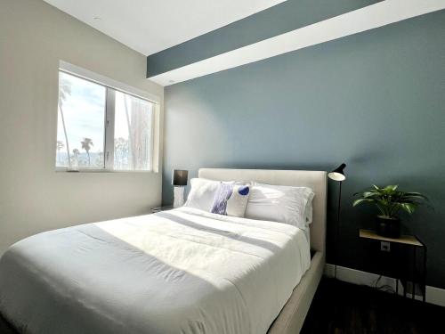 a bedroom with a large white bed with a window at Large Hollywood Corner 2 Bedroom with Private Balcony in Los Angeles