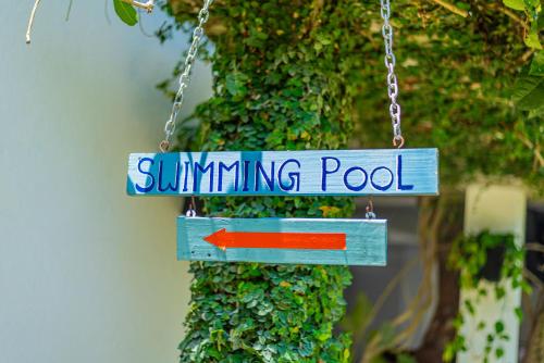 a sign that reads swimming pool with a red arrow at Eco Hotel Black & White - Anuradhapura in Mihintale