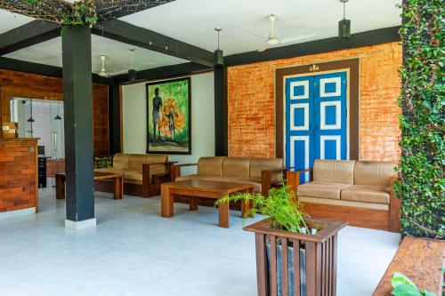 a lobby with couches and tables and a blue door at Eco Hotel Black & White - Anuradhapura in Mihintale
