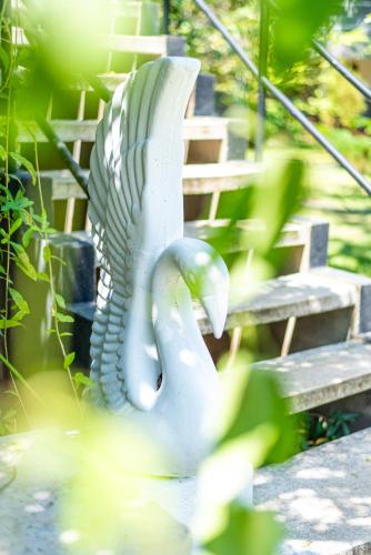 a statue of a swan sitting next to a bench at Eco Hotel Black & White - Anuradhapura in Mihintale