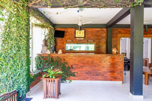 a restaurant with a brick wall with a clock on it at Eco Hotel Black & White - Anuradhapura in Mihintale