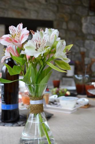 a glass vase with pink and white flowers in it at Casa Maru in Camarmeña