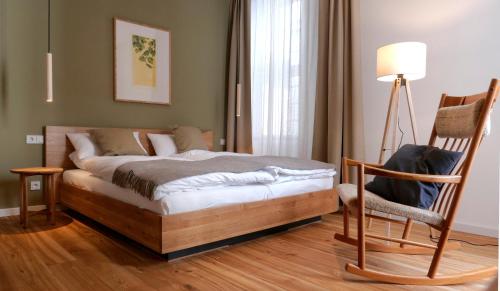 a bedroom with a bed and a chair and a lamp at klein & fein Gästehaus in Schwelm