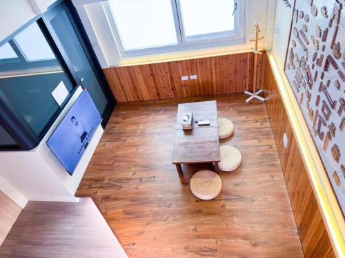 a room with a table and two stools on the floor at 慢步南國 雙包棟民宿 Slow Tainan Entire Home in Tainan