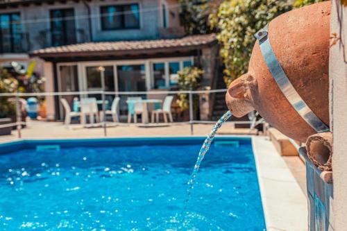 a fire hydrant pouring water into a swimming pool at Sirami Apartments in Taormina